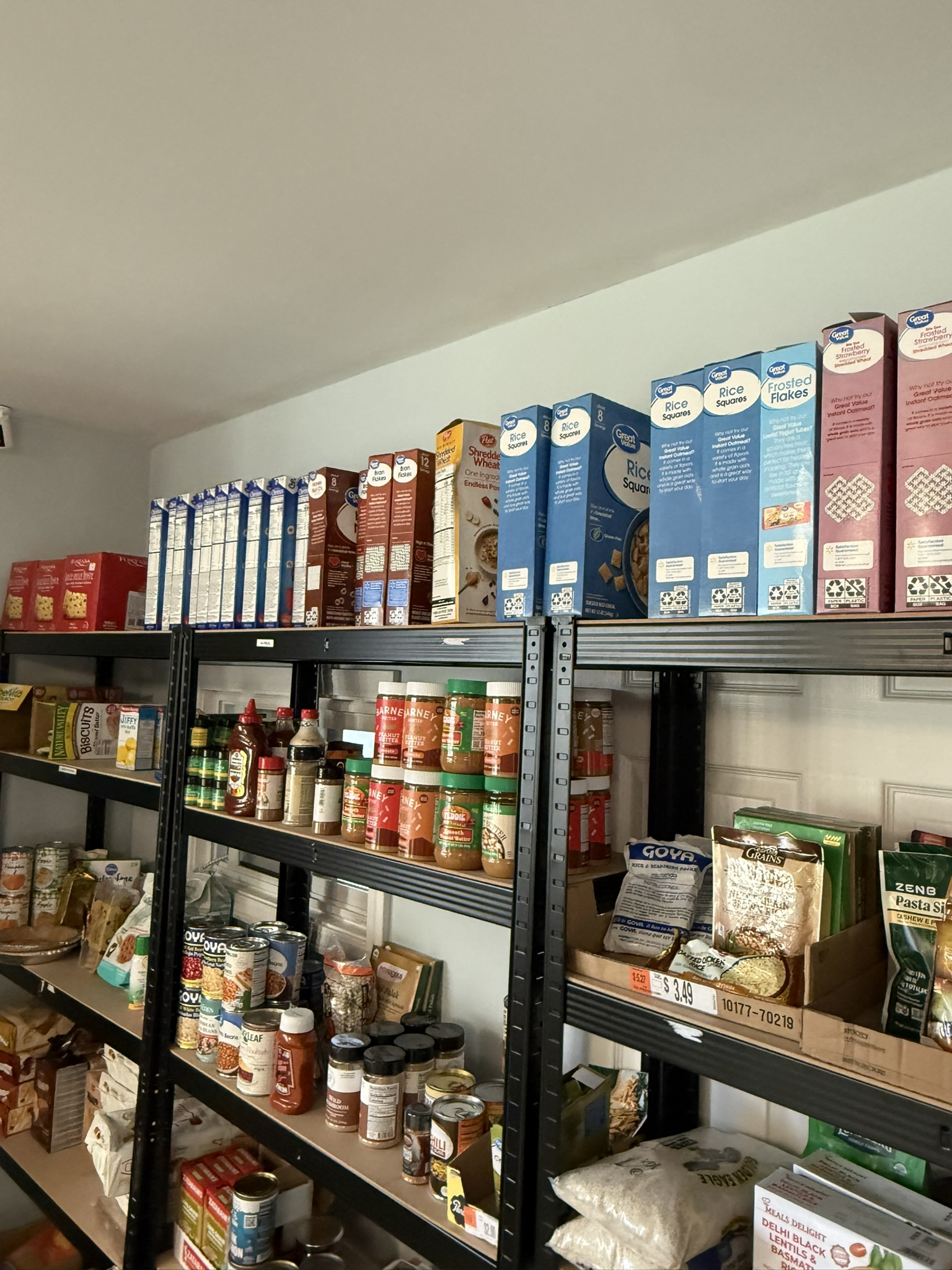 Pantry shelves stocked with cereal, peanut butter, canned food, and rice