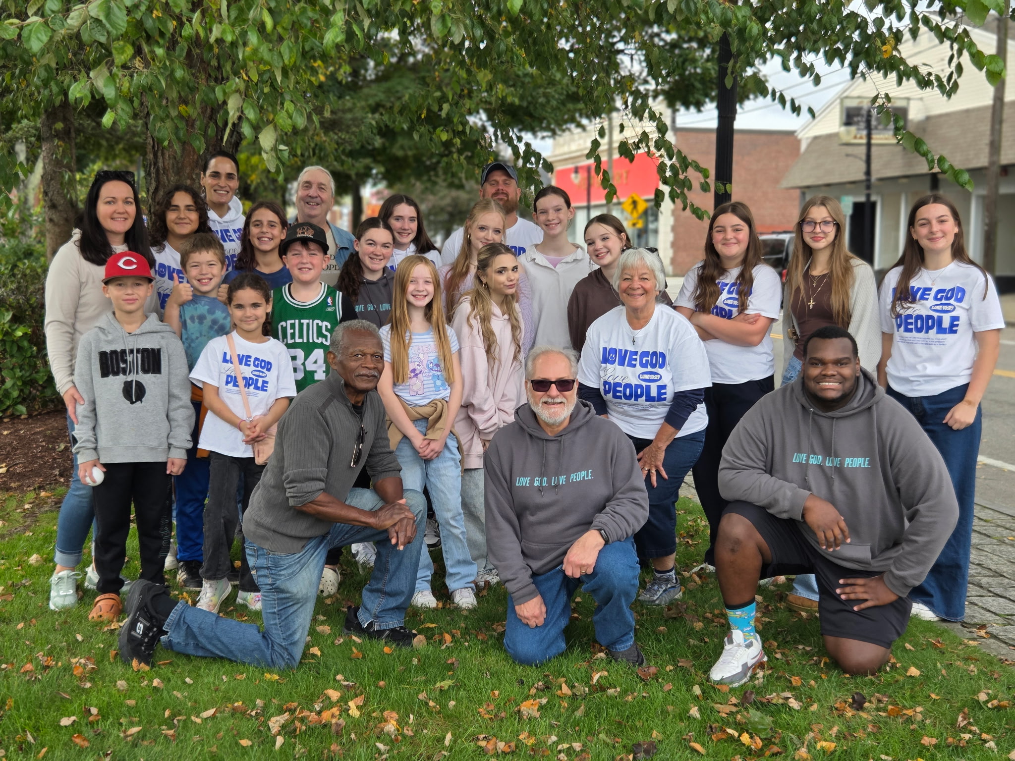 Living Faith children, youth, and adults gathered outdoors, wearing Love God. Love People. shirts