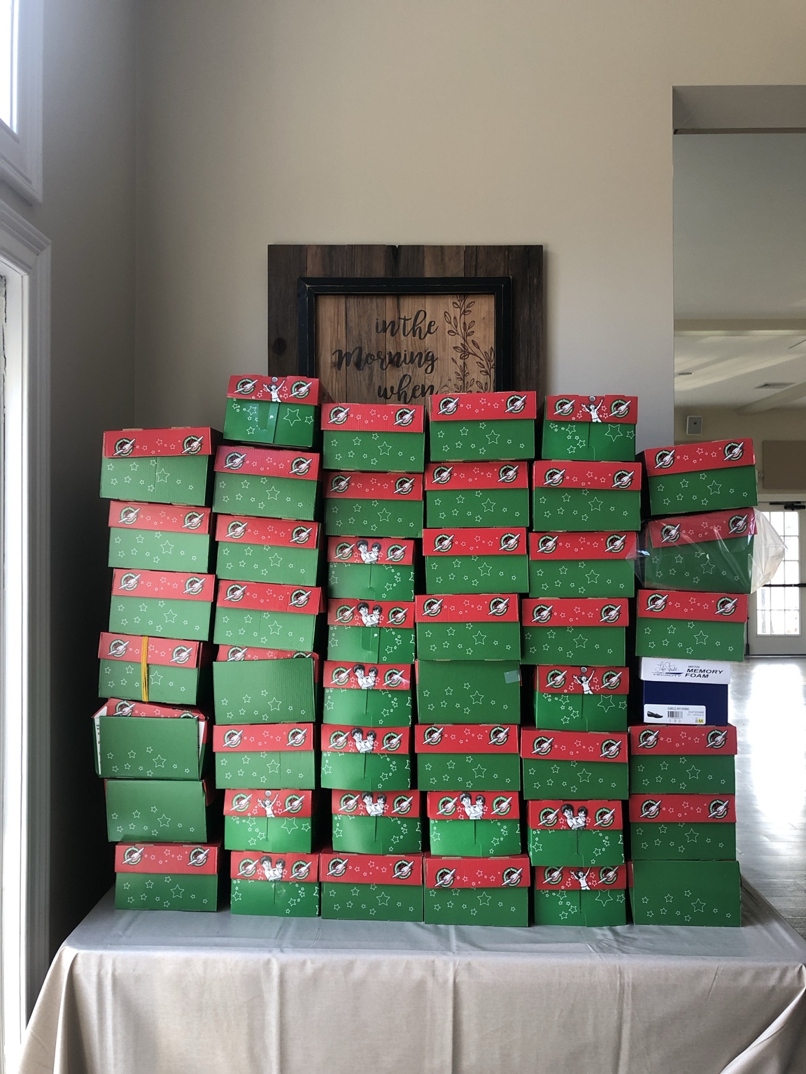 Operation Christmas Child shoeboxes collected at Living Faith, stacked on a table.