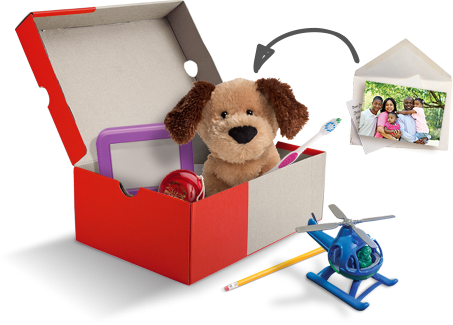 An open shoebox with toys, school supplies, and a personal note and photo.