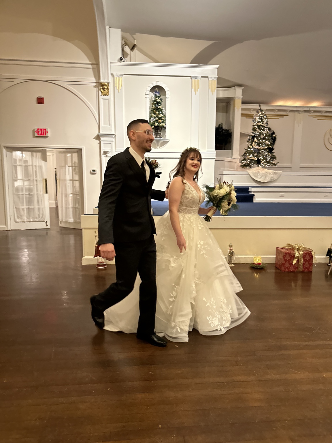 A smiling bride and groom walking together at their wedding